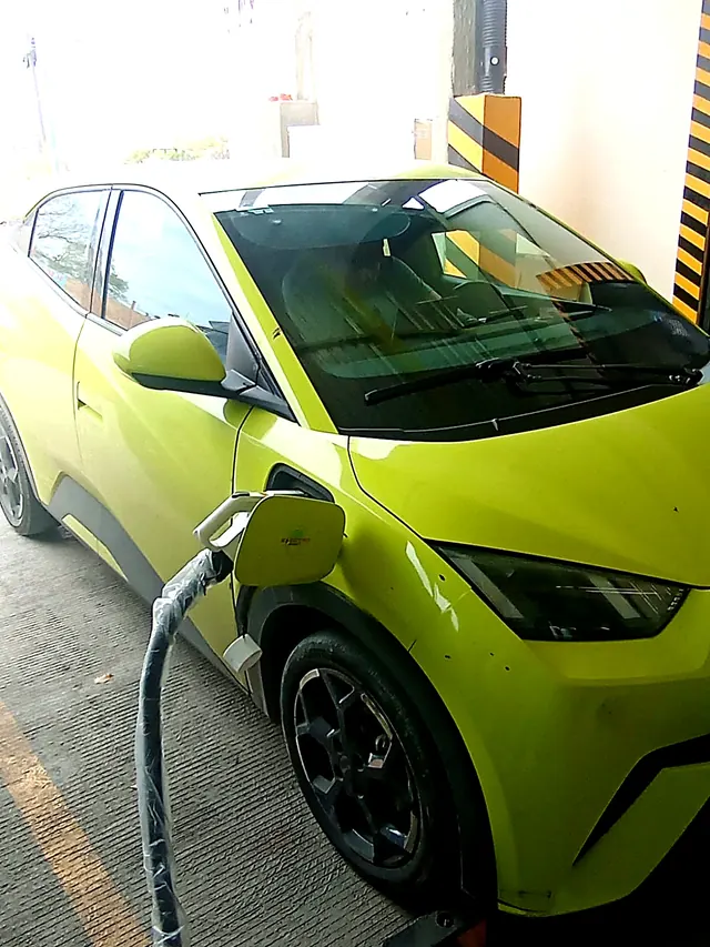 Auto eléctrico verde lima cargando