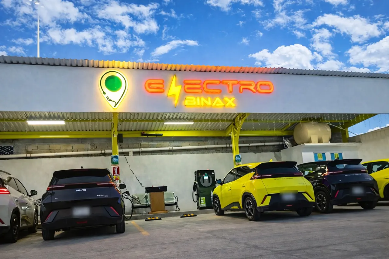 Fachada de ELECTROBINAX de día, con la techumbre verde y el letrero