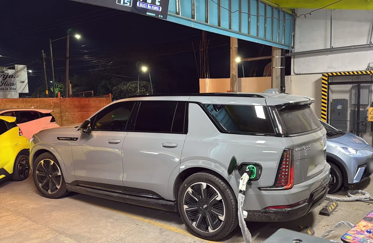 Camioneta eléctrica cargando de noche en la estación
